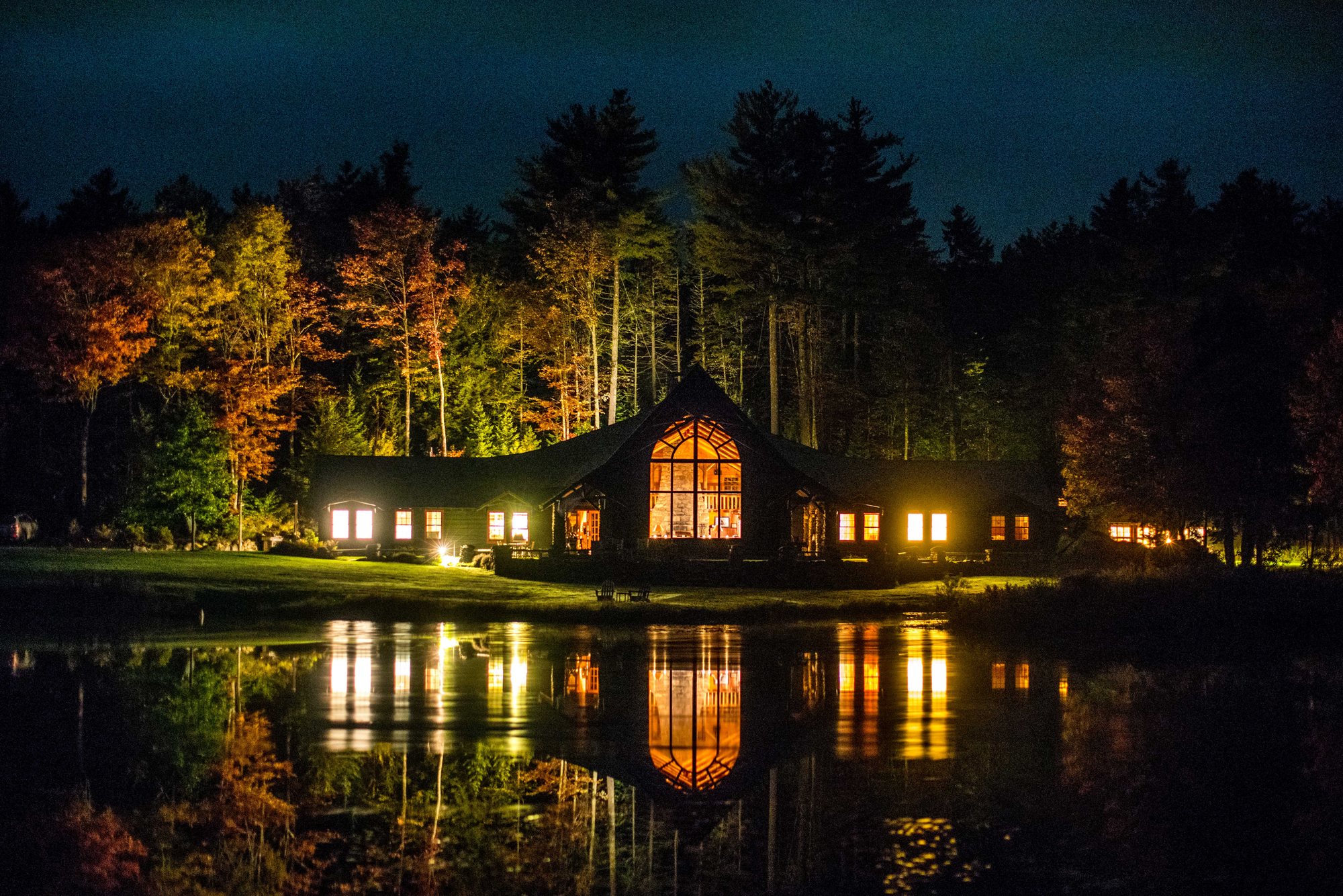 The Lodge lit up across the pond at night