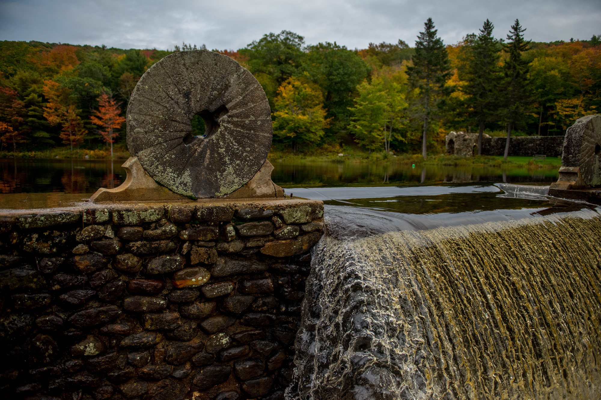 A millstone set above the waterfall on the old dam