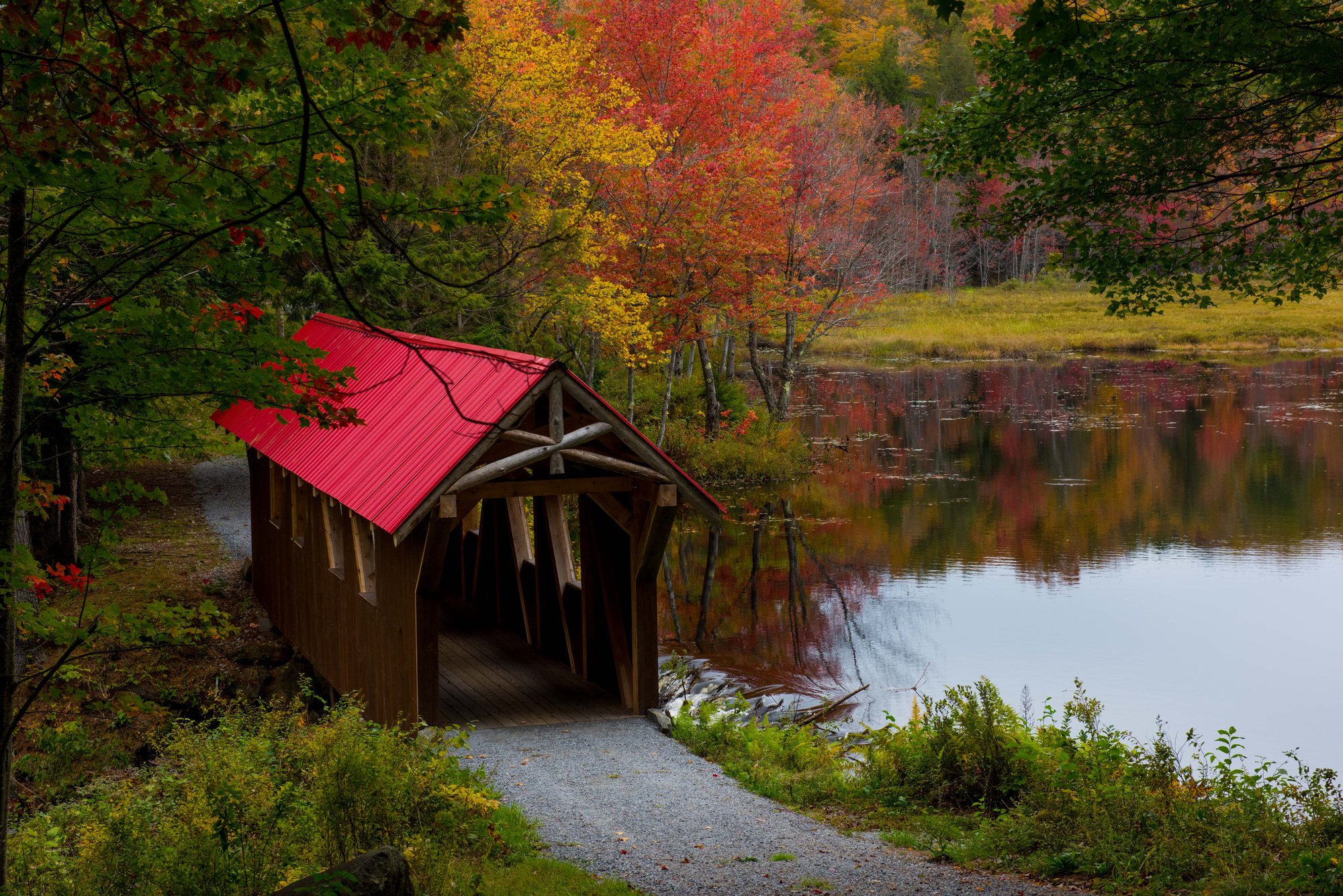 The covered bridge with its red roof in fall