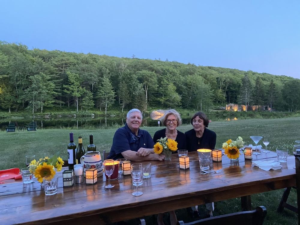 The Healy family at a long table on the lawn at dusk