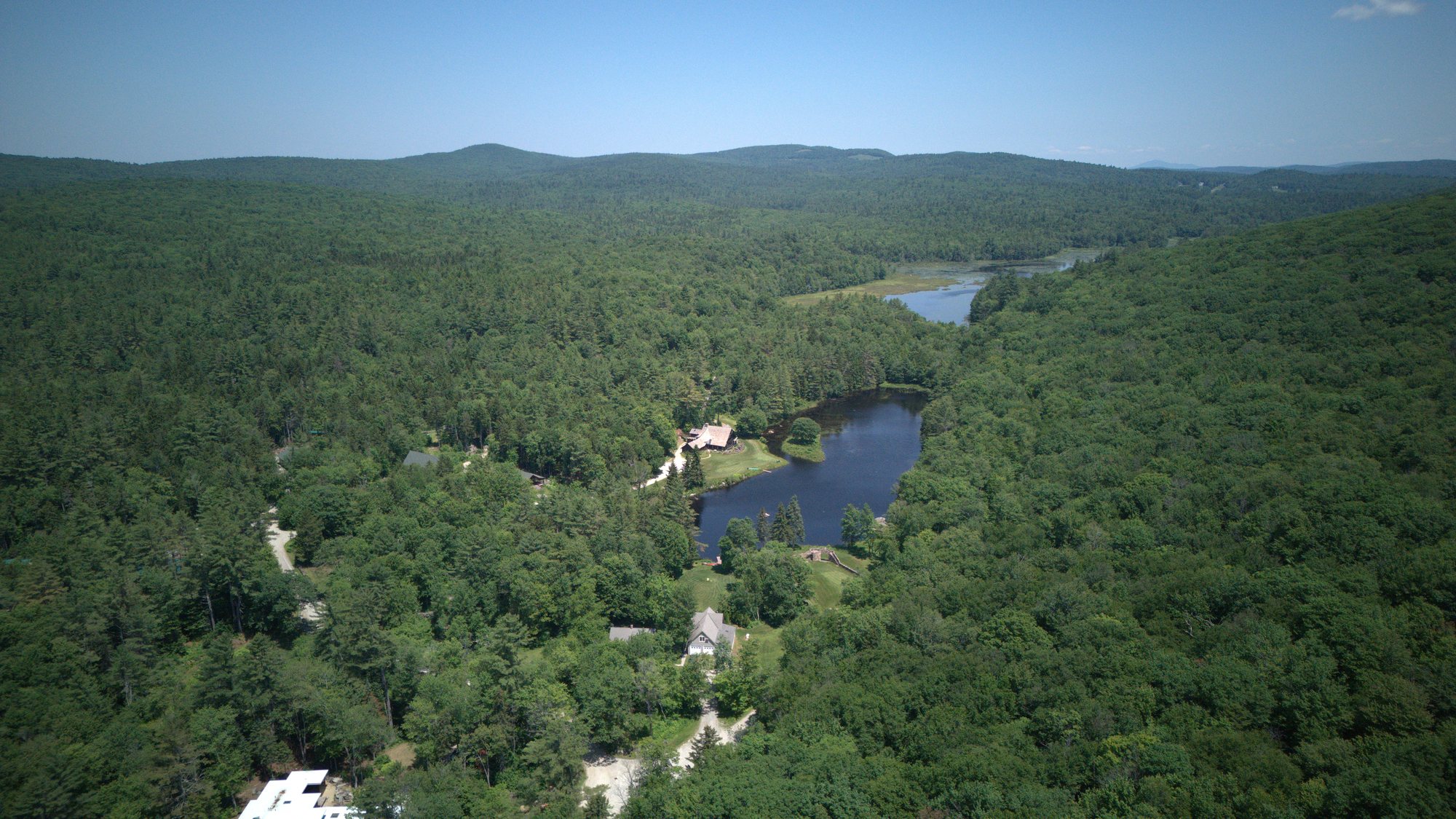 The estate and the pond among the forested hills of the Monadnock region