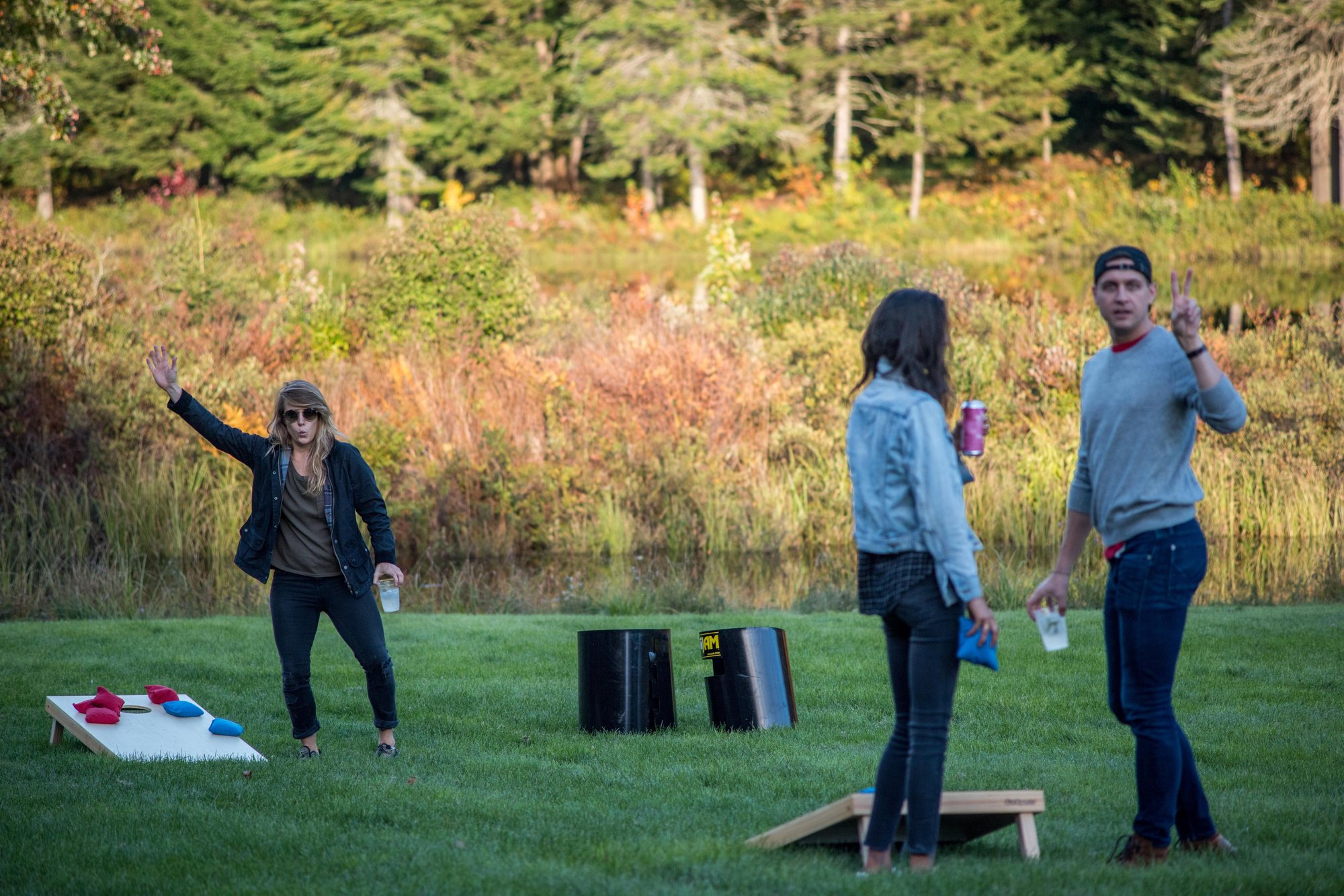 A game of cornhole on the lawn by the marsh