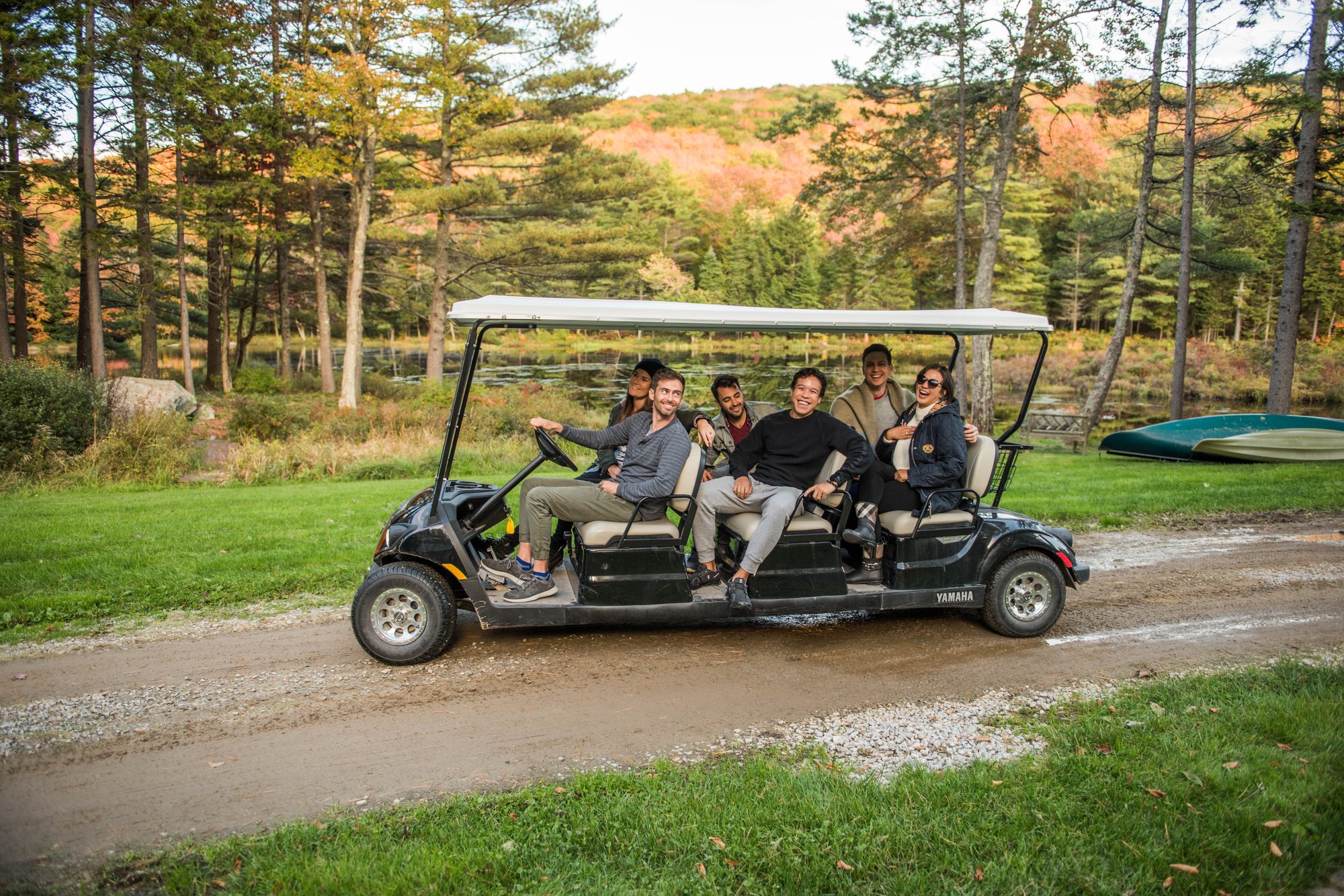 A group riding the estate cart along the pond road