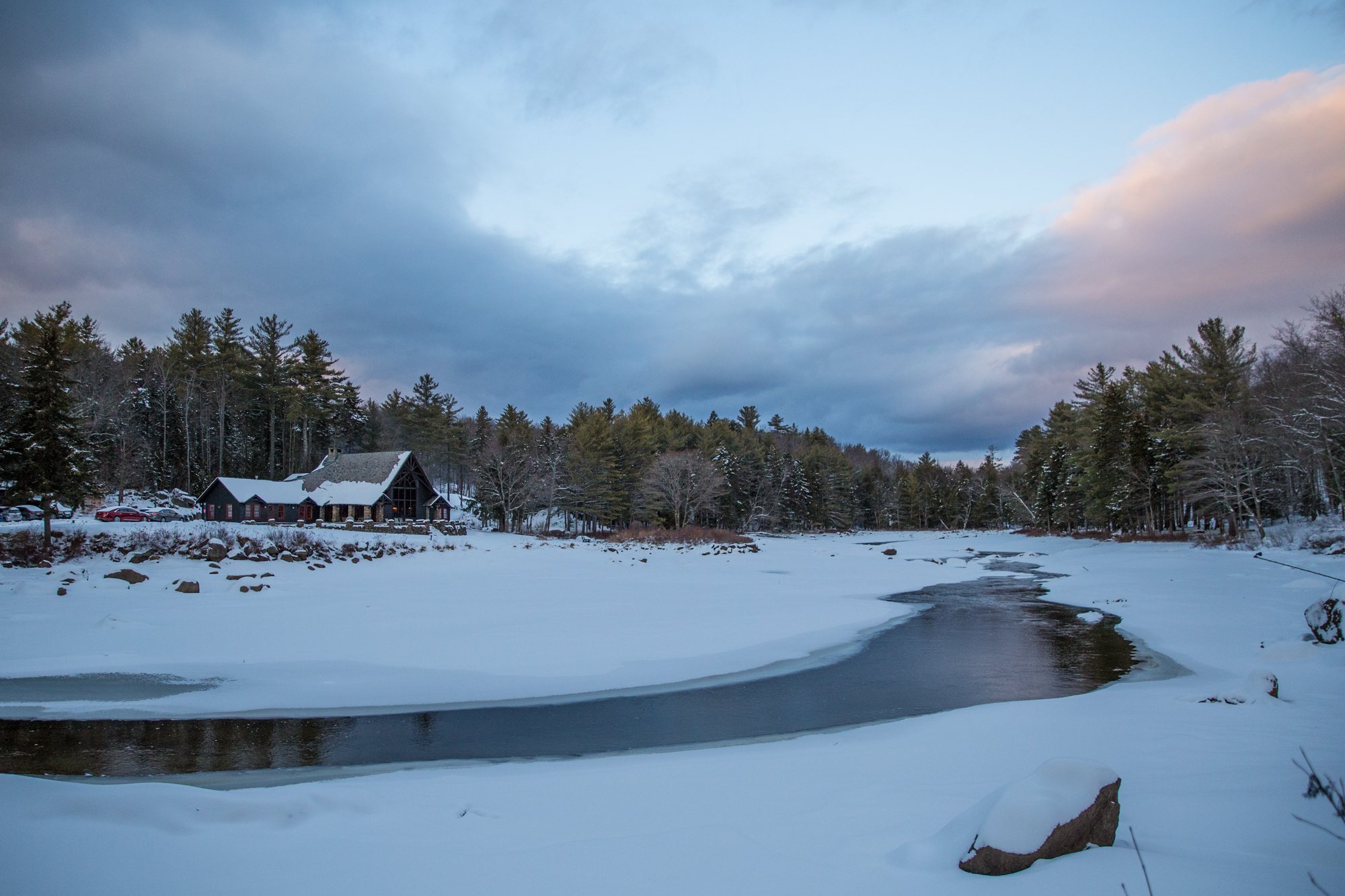 The Lodge across the frozen pond under a winter evening sky