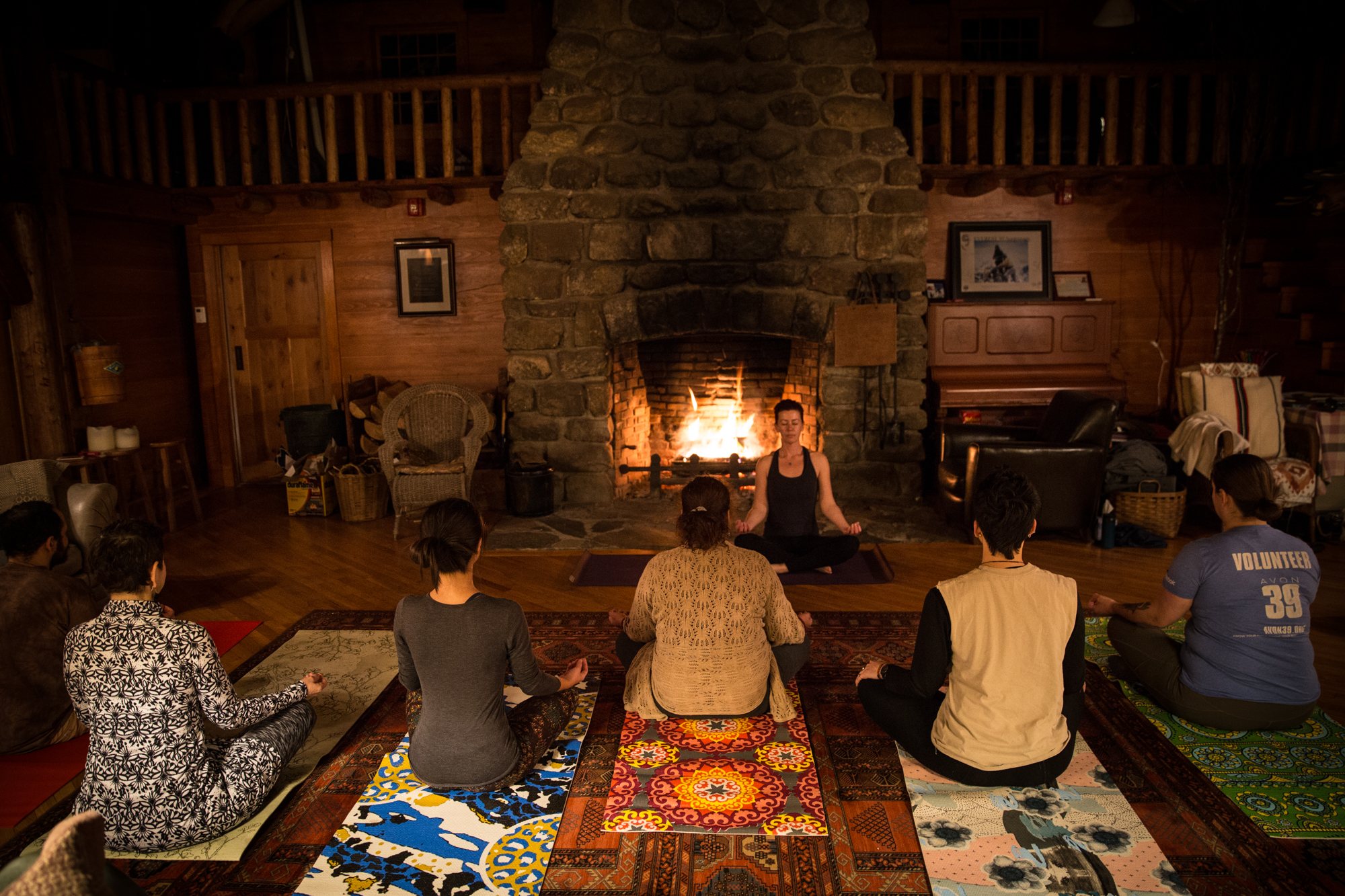 A group sitting together by the fire in the Lodge at night