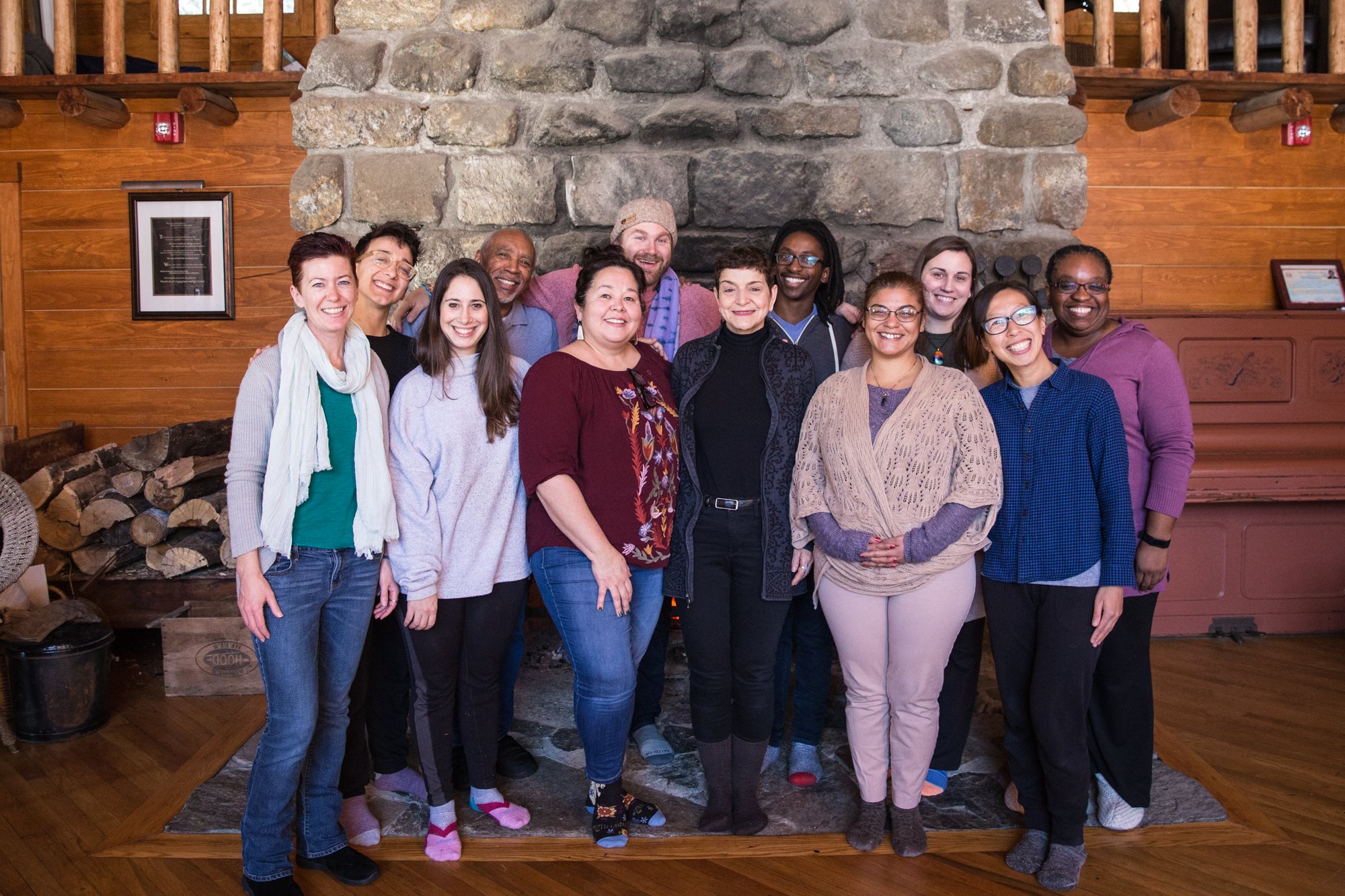 A group standing together in front of the Lodge fireplace