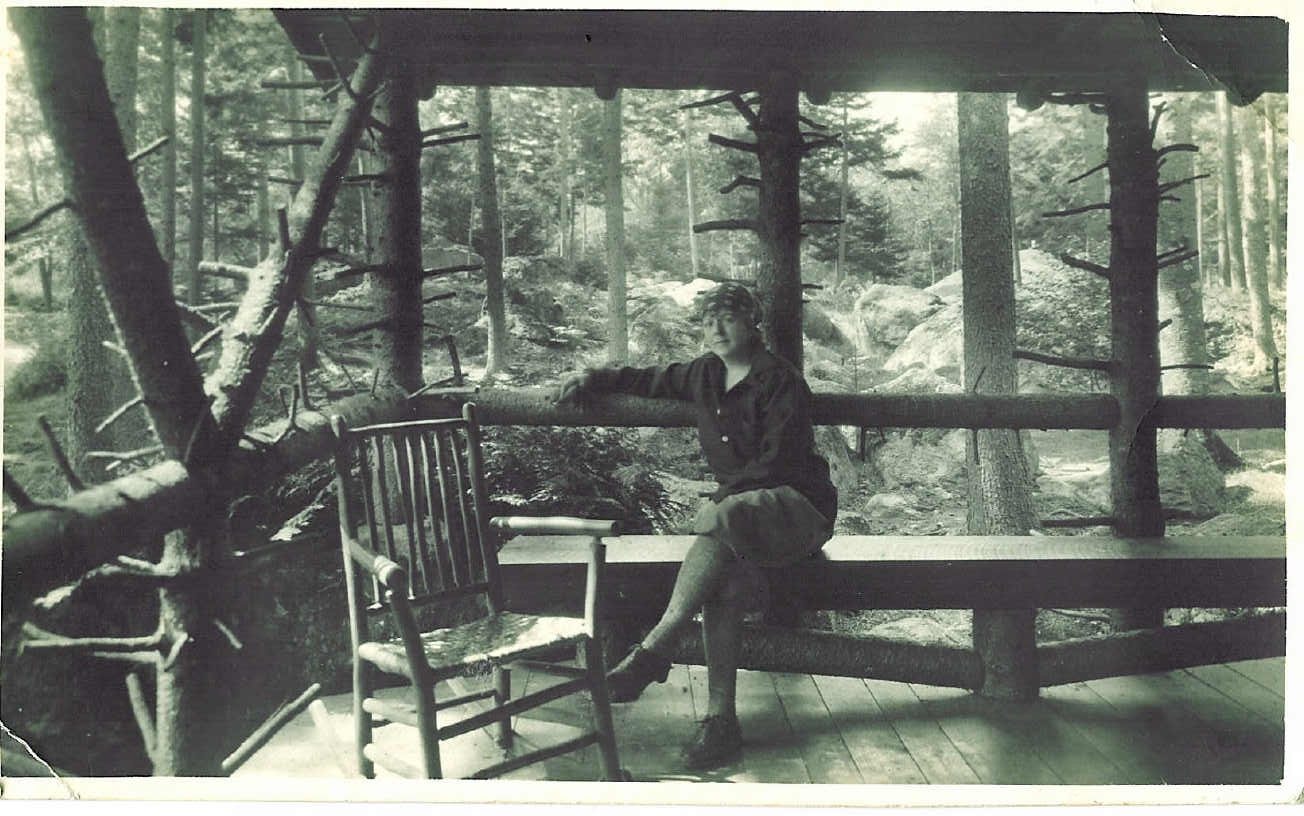 Florence Brooks Aten on the porch of her cabin in the woods
