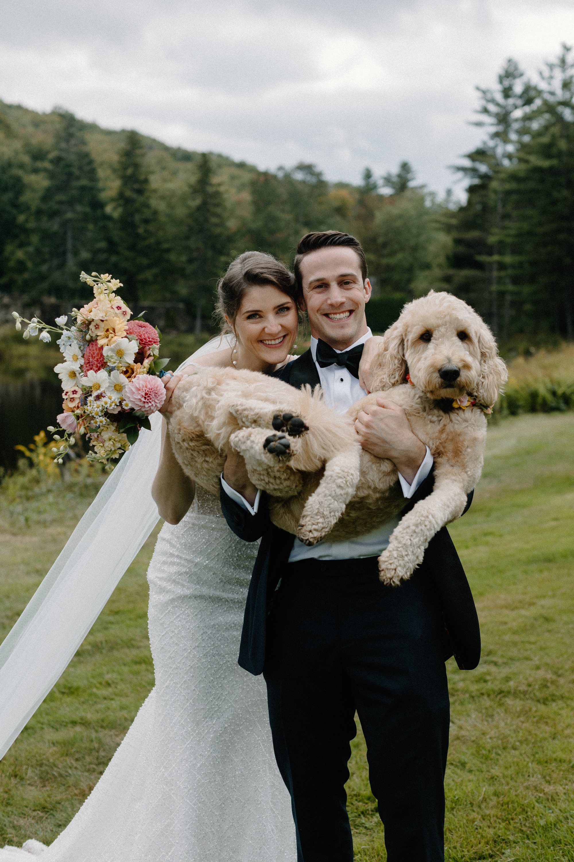 The two of them with their dogs and her bouquet on the lawn
